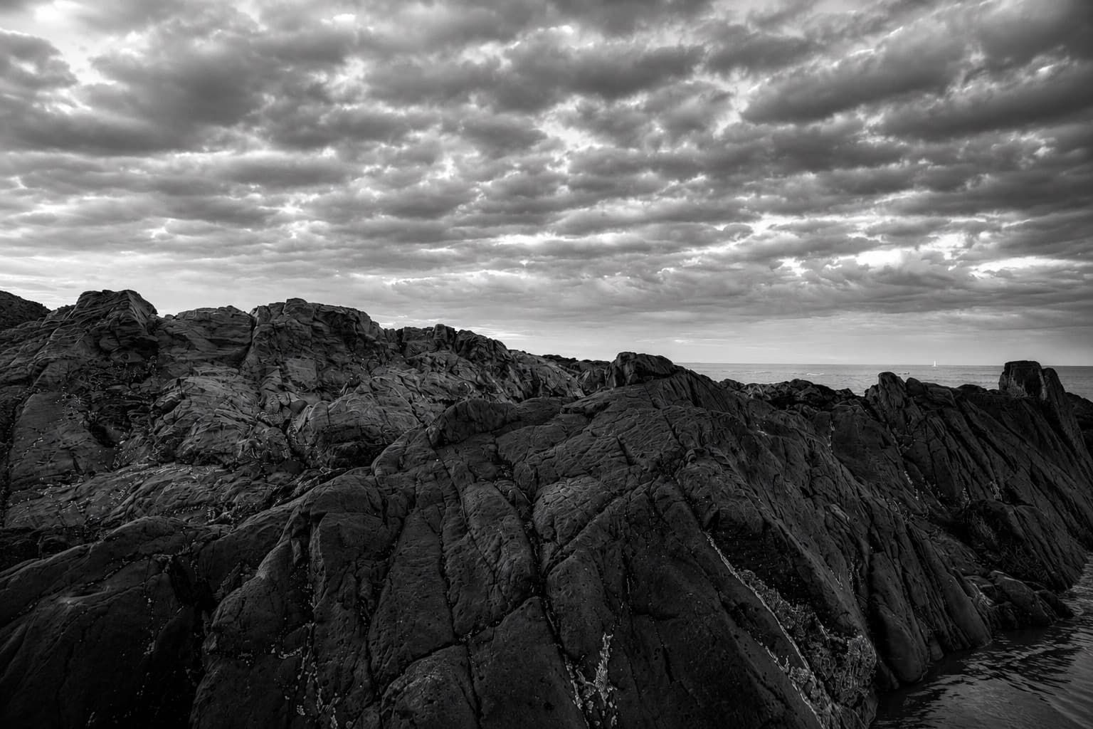 Rocky Maine coastline under a dramatic sky