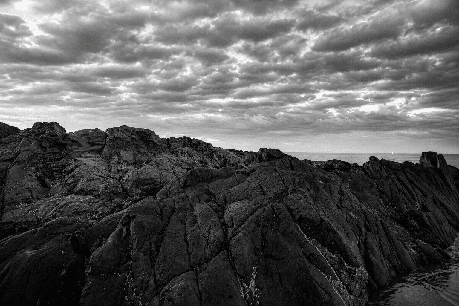 Rocky Maine coastline under a dramatic sky