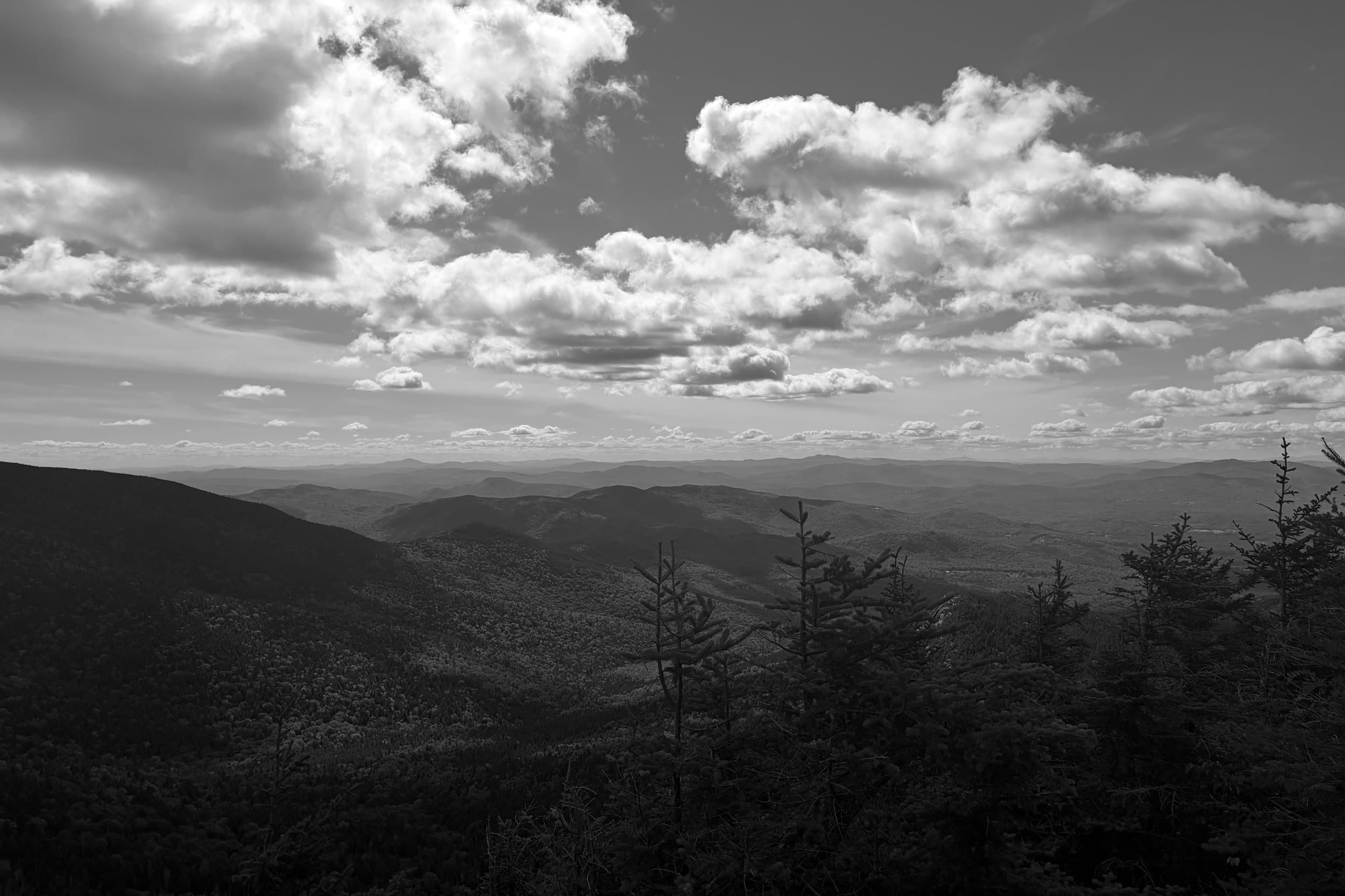 Forested mountains and open sky seen from a summit in New England